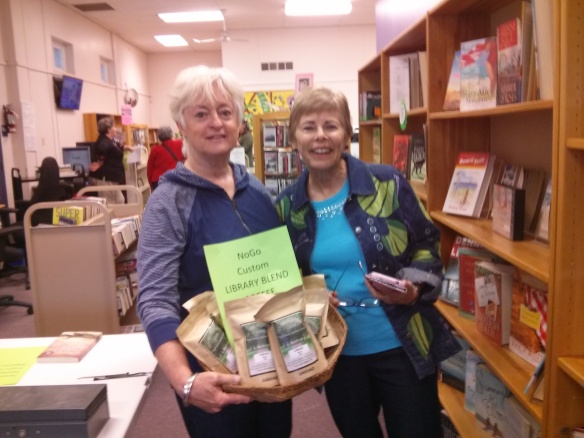 Community members Karen Craig (L) and Christiane Bollinger at the Sidewalk Sale Saturday. In the basket, special custom Library Blend coffee, prepared just for us!
